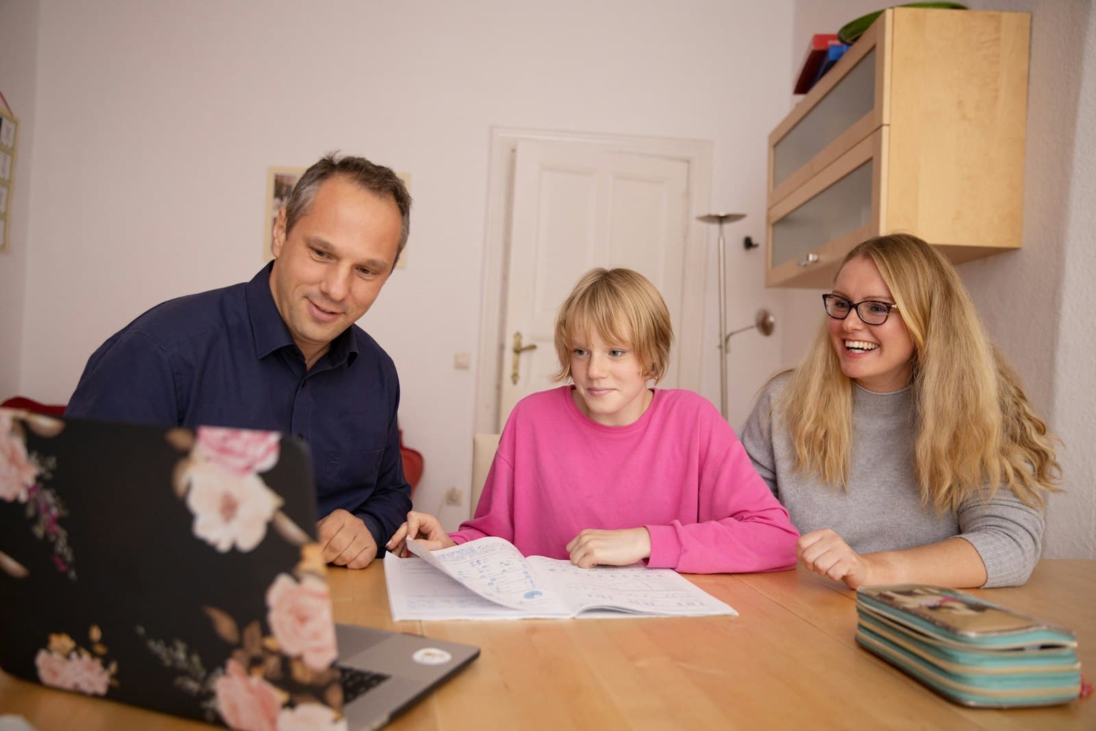 A facilitator supporting a parent and child through a learning activity